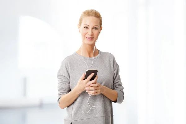 Блондинка використовує свій мобільний телефон — стокове фото