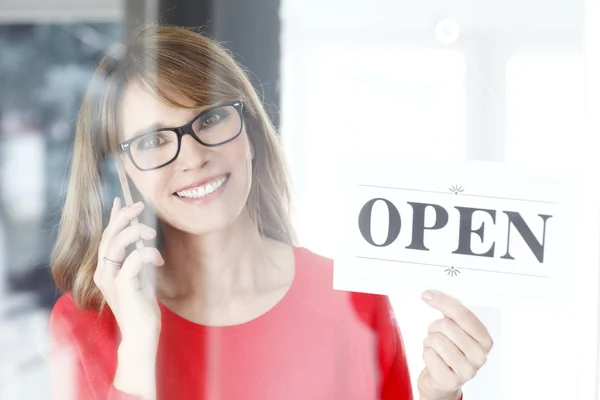 Mujer sosteniendo en su mano signo abierto — Foto de Stock