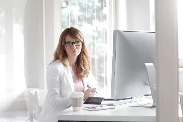 Femme d'affaires assise dans son bureau — Photo