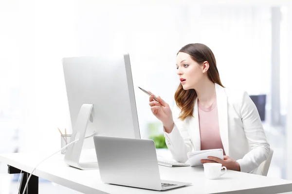 Trabajadora sentada en su escritorio y trabajando —  Fotos de Stock