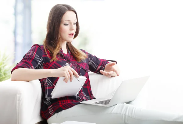 Donna seduta sul divano con computer portatile — Foto Stock