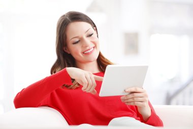 Oturma sırasında dijital tablet kullanan kadın