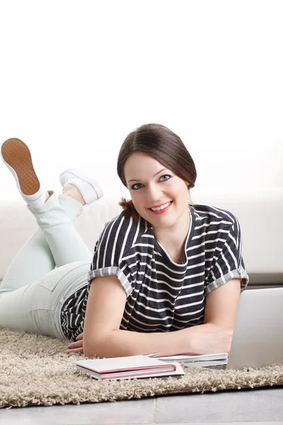 Woman using her laptop while lying — Stock Photo, Image