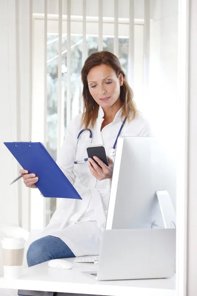 Kvinnliga läkare använder sin mobiltelefon — Stockfoto