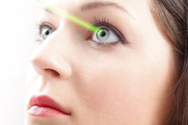 Женский глаз с медицинским лазером

