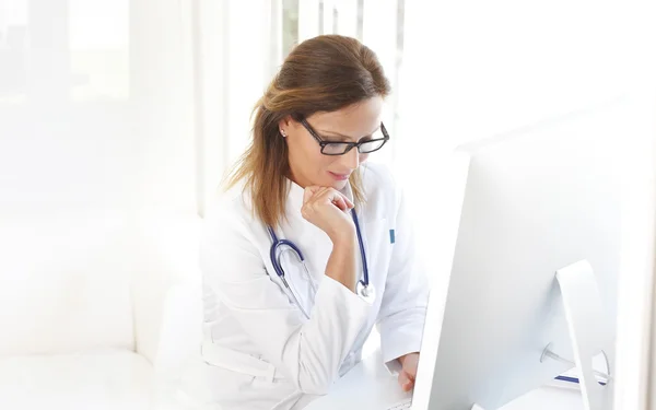 Läkare sitter vid skrivbord och dator — Stockfoto