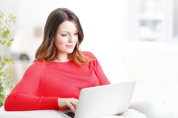 Mujer usando el ordenador portátil mientras está sentado — Foto de Stock