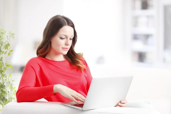 Mulher usando laptop enquanto sentado — Fotografia de Stock