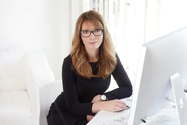 Businesswoman sitting at her workplace. Royalty Free Stock Photos