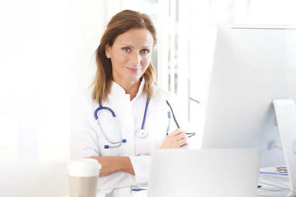 Doctor sentado en el consultorio del doctor — Foto de Stock