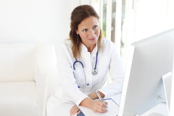 Doctor escribiendo en portapapeles — Foto de Stock