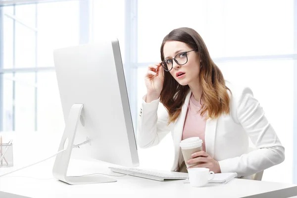 Business woman sitting at desk in front of monitor w — стоковое фото