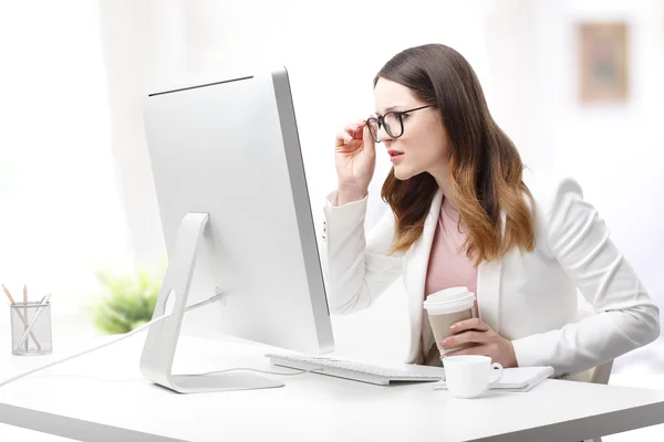 Mujer de negocios sentada en el escritorio delante del monitor w —  Fotos de Stock