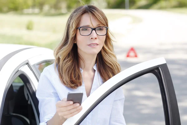 Femme debout à sa voiture en panne — Photo