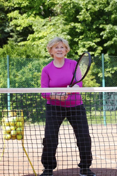 Жінка стоїть в мережі на тенісному корті — стокове фото