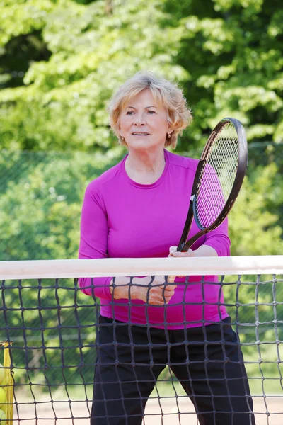 Äldre kvinna spela tennis — Stockfoto