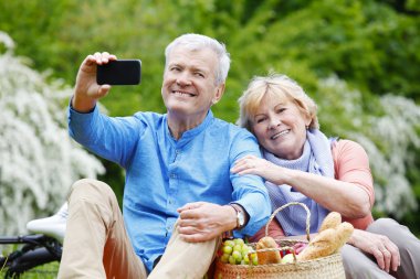 Çift akıllı telefonla selfie çekiyor. 