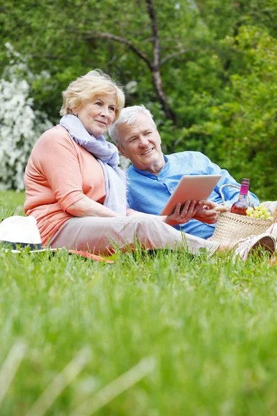 Couple aîné utilisant une tablette numérique . — Photo