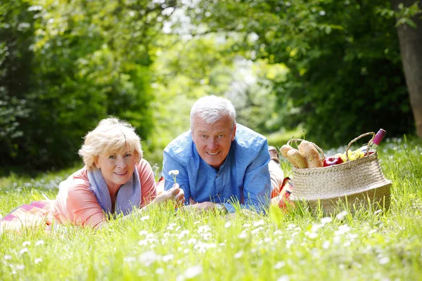 Para starszych, leżąc na trawie — Zdjęcie stockowe
