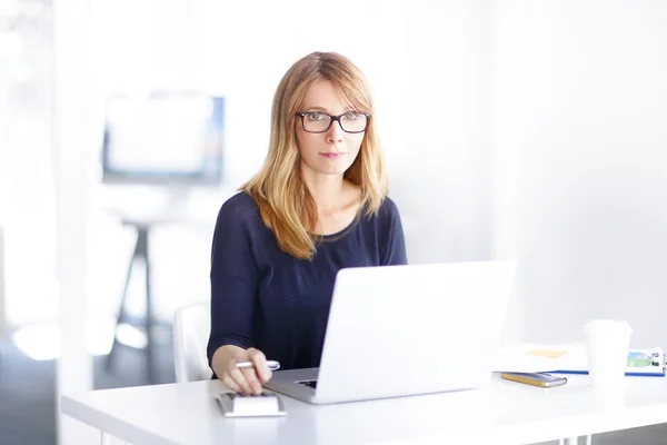 Affärskvinna som sitter framför laptop — Stockfoto