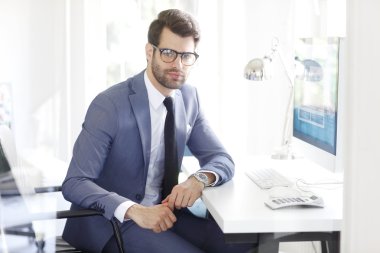 Bilgisayarda çalışan yakışıklı işadamı 