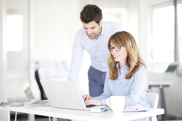 Zakenvrouw en assistent met behulp van laptop — Stockfoto