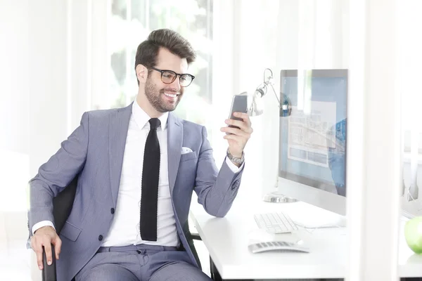 Assistente de banco usando seu telefone móvel — Fotografia de Stock