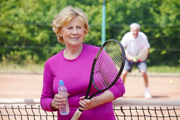 Kvinna som står på tennisbanan — Stockfoto