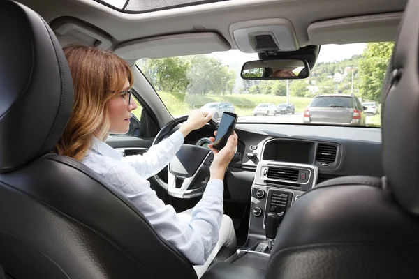 Driver using her mobile phone — Stock Photo, Image