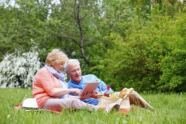 Couple aîné utilisant une tablette numérique — Photo