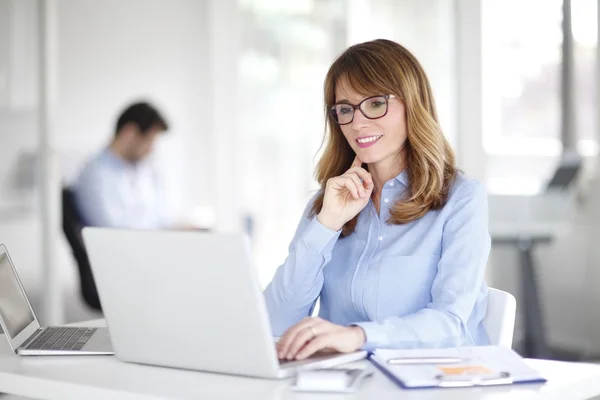 Mulher usando laptop enquanto trabalhava — Fotografia de Stock