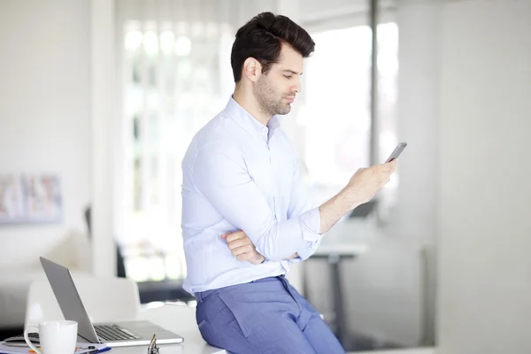 Professionell man använder sin mobiltelefon — Stockfoto