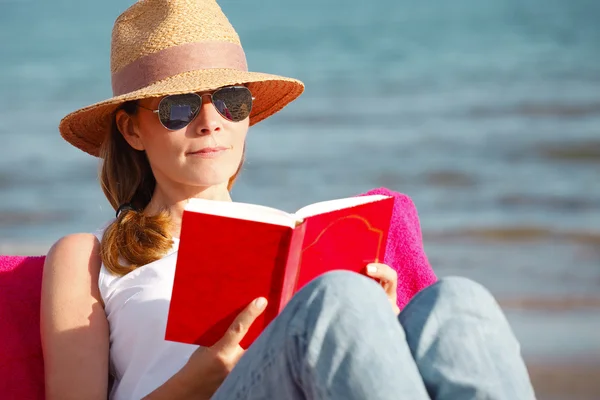 Vrouw die boek leest op het strand — Stockfoto