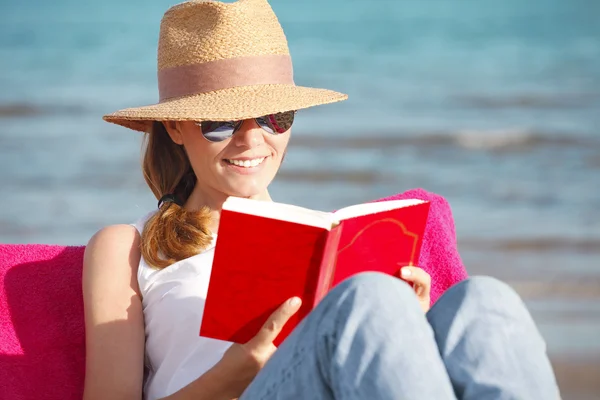 Frau liest Buch am Strand — Stockfoto