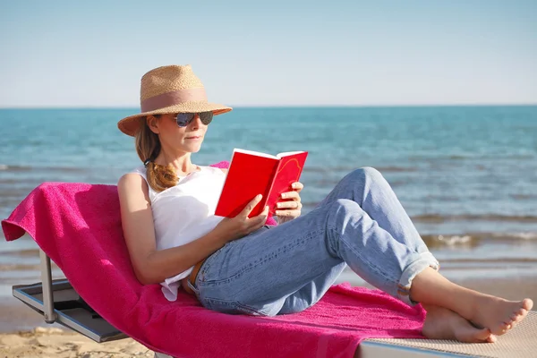 ビーチで本を読んでいる女性は — ストック写真