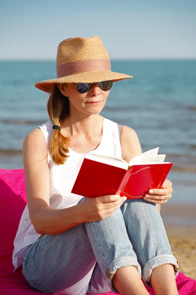 Frau liest Buch am Strand — Stockfoto