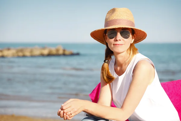 Жінка сидить біля моря — стокове фото