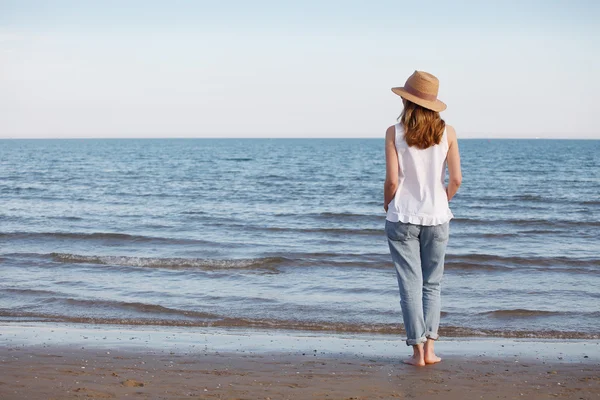 Женщина стоит на песчаном пляже — стоковое фото
