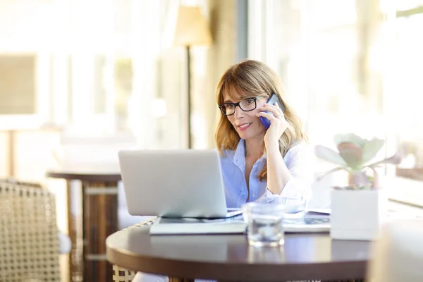 Vrouw met mobiele en laptop vergadering — Stockfoto