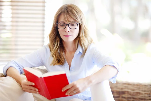 Frau liest ein Buch und entspannt sich — Stockfoto