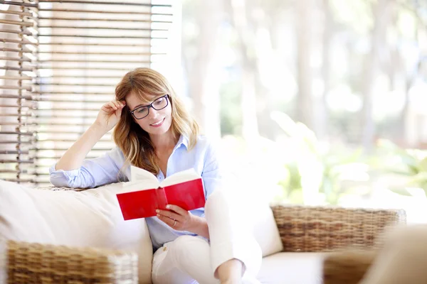 Mulher de meia idade lendo um livro — Fotografia de Stock