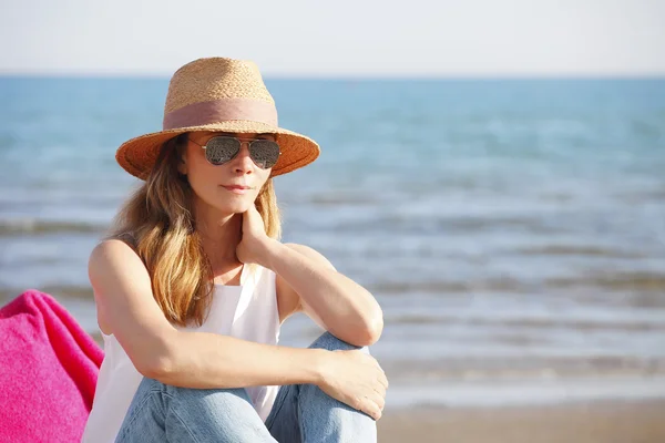 Mujer sentada junto al mar y relajada — Foto de Stock
