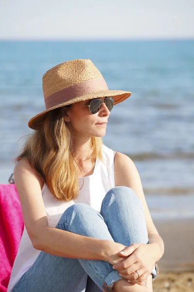 Mujer sentada en la playa. — Foto de Stock
