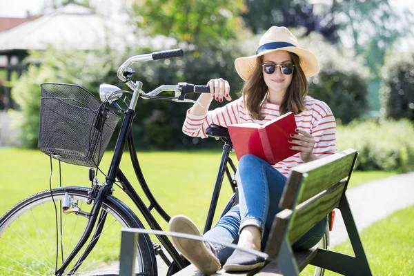 Kvinna läser en bok i parken — Stockfoto