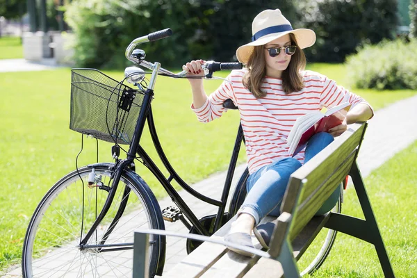 Kvinna läser en bok i parken — Stockfoto