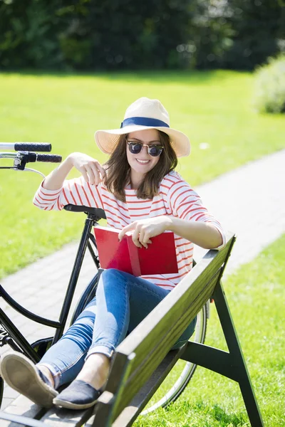 Een vrouw die een boek leest in het park — Stockfoto