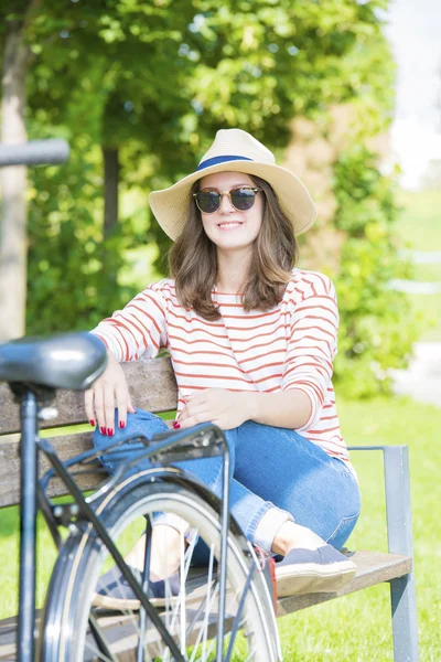 Kvinne som sitter på benken i park – stockfoto