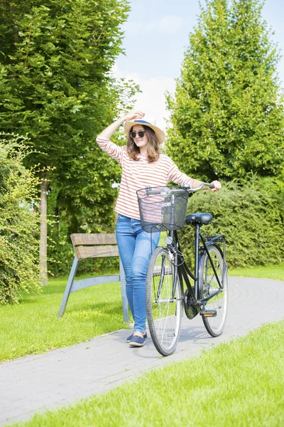 Kvinna med hennes cykel walking — Stockfoto