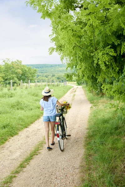 Mulher empurrando sua bicicleta — Fotografia de Stock