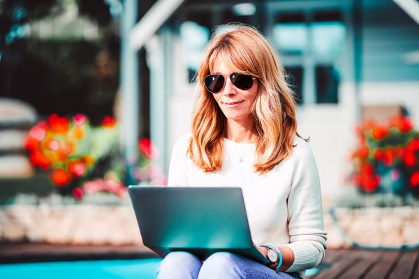 Sorridente Donna Matura Utilizzando Computer Portatile Mentre Seduto Giardino Lavorare — Foto Stock